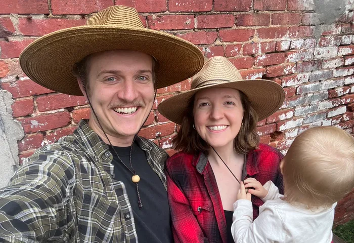 Cody and Emily in straw hats against a brick wall in Lancaster