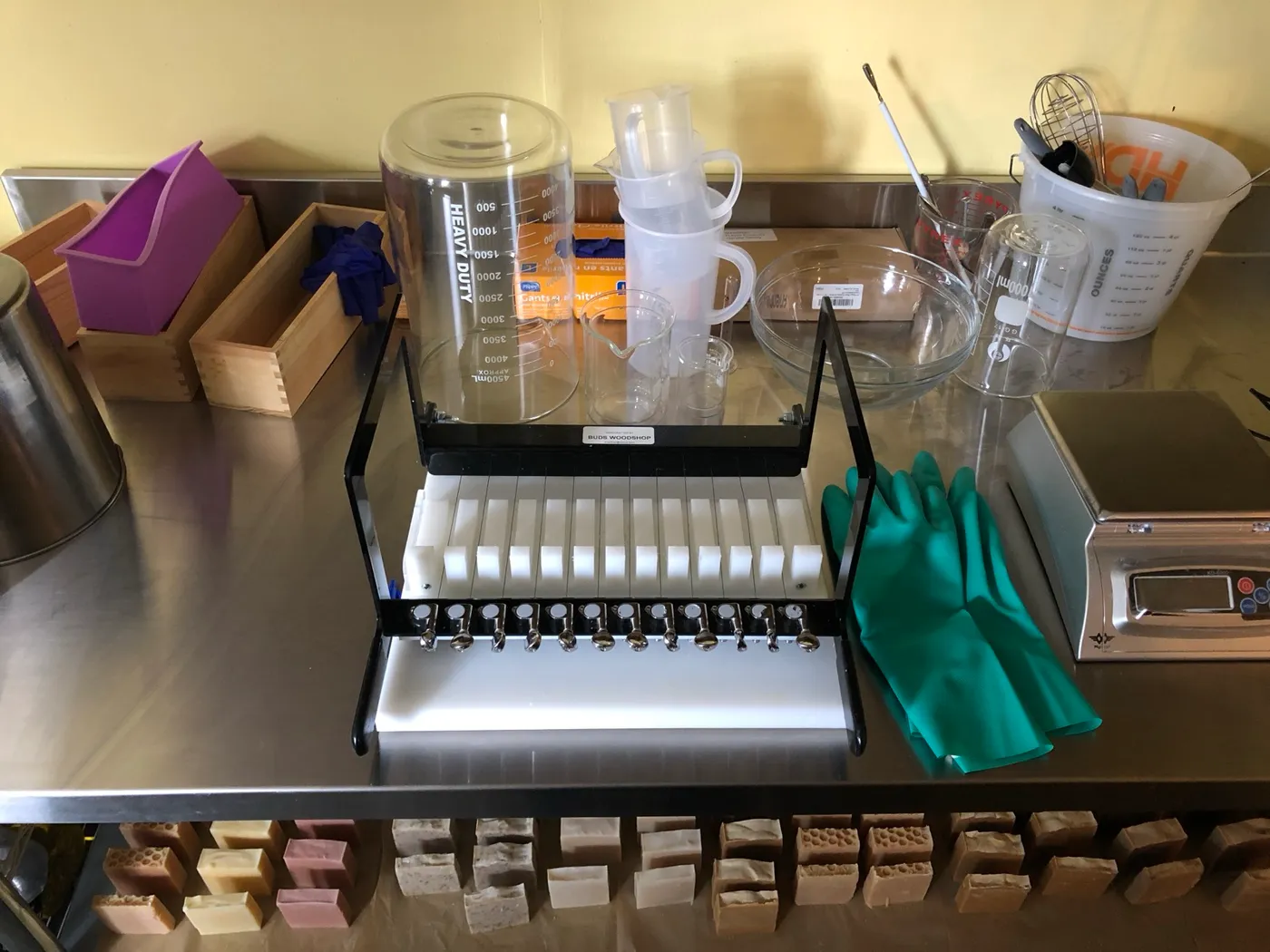 The soap work table: wire cutter, beakers, scale, and gloves, with cut bars curing below